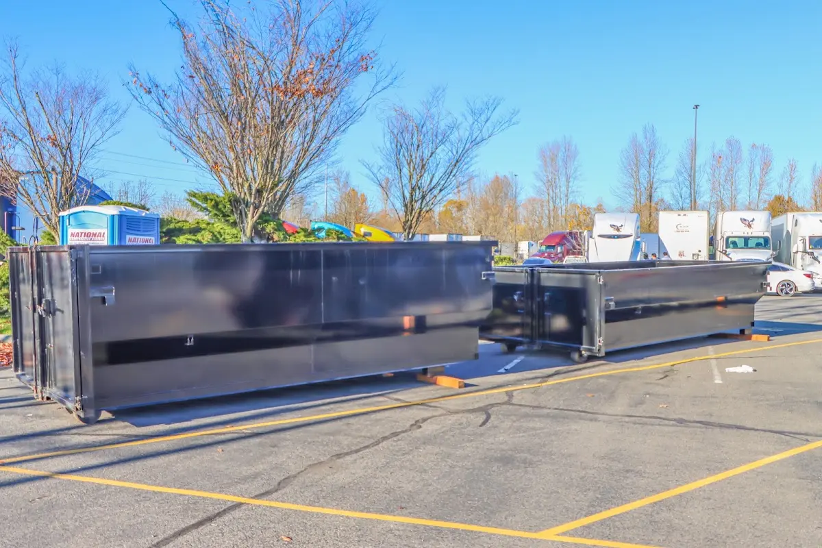 Professional dumpster rental service with roll-off container on residential driveway in Revere